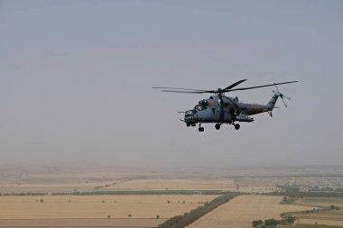 Almaty / Kazakistan - 08.25.2020: Konut binaları, çeşitli altyapı ve tarım arazileri olan bir şehir üzerinde askeri helikopterin kalkışı.