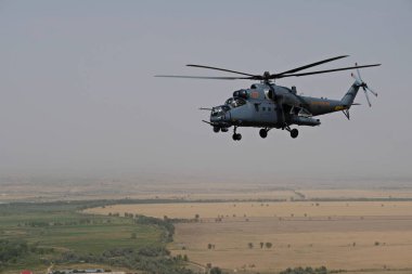 Almaty / Kazakistan - 08.25.2020: Konut binaları, çeşitli altyapı ve tarım arazileri olan bir şehir üzerinde askeri helikopterin kalkışı.