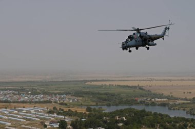 Almaty / Kazakistan - 08.25.2020: Konut binaları, çeşitli altyapı ve tarım arazileri olan bir şehir üzerinde askeri helikopterin kalkışı.