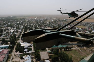 Almaty / Kazakistan - 08.25.2020: Konut binaları, çeşitli altyapı ve tarım arazileri olan bir şehir üzerinde askeri helikopterin kalkışı.