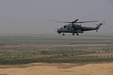 Almaty / Kazakistan - 08.25.2020: Konut binaları, çeşitli altyapı ve tarım arazileri olan bir şehir üzerinde askeri helikopterin kalkışı.