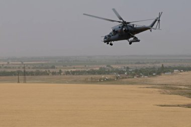 Almaty / Kazakistan - 08.25.2020: Konut binaları, çeşitli altyapı ve tarım arazileri olan bir şehir üzerinde askeri helikopterin kalkışı.