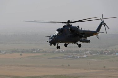 Almaty / Kazakistan - 08.25.2020: Konut binaları, çeşitli altyapı ve tarım arazileri olan bir şehir üzerinde askeri helikopterin kalkışı.