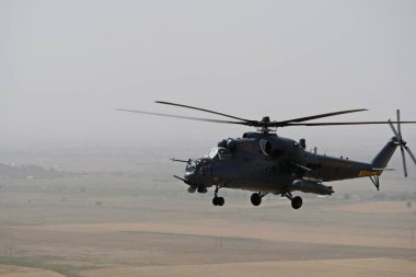 Almaty / Kazakistan - 08.25.2020: Konut binaları, çeşitli altyapı ve tarım arazileri olan bir şehir üzerinde askeri helikopterin kalkışı.