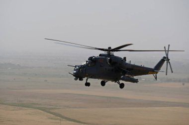 Almaty / Kazakistan - 08.25.2020: Konut binaları, çeşitli altyapı ve tarım arazileri olan bir şehir üzerinde askeri helikopterin kalkışı.