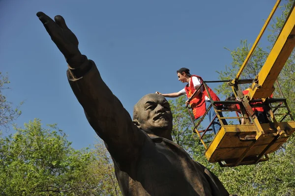 Almaty / Kazakistan - 04.21.2012: Komünist parti kostümlü insanlar parkta Lenin heykelini yıkıyorlar.