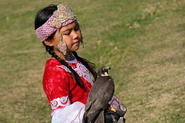 アルマティ カザフスタン 2020 カザフスタンの国民服の少女は彼女の腕の中でBalabanファルコンを保持しています — ストック写真