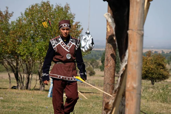 アルマティ カザフスタン 2020 弓を持つ民族衣装の10代は ターゲットの近くに矢印を収集します — ストック写真