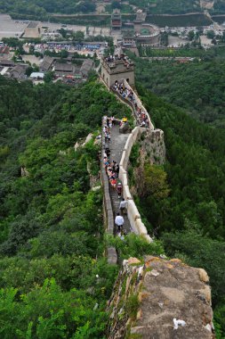 Pekin / Çin - 08.05.2012: Dünyanın dört bir yanından gelen turistler Çin Seddi boyunca yolun bir kısmında yürüyorlar. Dağların ve tepelerin manzarası.