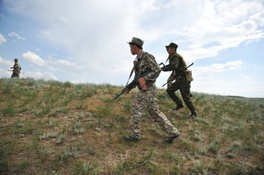 Almaty / Kazakistan - 05.17. 2012: Silahlı askerler sahadaki eğitim sahasına gidiyor.