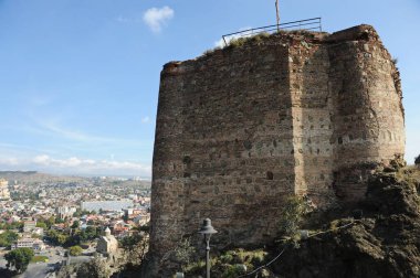 Gürcistan / Tiblis - 10.26.2012: Eski kale kompleksi - Narikala. Duvarın tepesinde çanlar olan bir parçası.