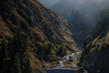 Almaty / Kazakistan - 09.25.2020: Teleferiğin yüksekliğinden farklı bitki örtüsüne sahip Medeo yolu ve dağların görüntüsü.