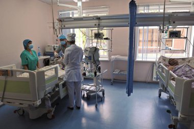 Almaty / Kazakistan - 08.23.2012: Doktorlar ve sağlık personeli ameliyattan sonra koğuşta hastanın durumunu kontrol ediyorlar