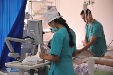 Almaty / Kazakistan - 08.23.2012: Doktorlar ve sağlık personeli ameliyattan sonra koğuşta hastanın durumunu kontrol ediyorlar