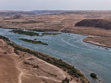Ili Nehri ve kumlu kıyı bölgesi. Semirechye 'deki en büyük nehir. İnsansız hava aracının görüntüsü. Yılın yaz zamanı..