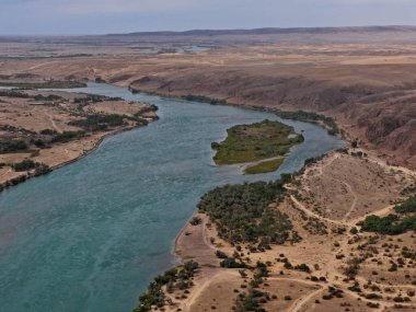 Ili Nehri ve kumlu kıyı bölgesi. Semirechye 'deki en büyük nehir. İnsansız hava aracının görüntüsü. Yılın yaz zamanı..