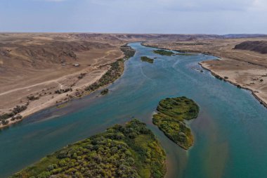 Ili Nehri ve kumlu kıyı bölgesi. Semirechye 'deki en büyük nehir. İnsansız hava aracının görüntüsü. Yılın yaz zamanı..