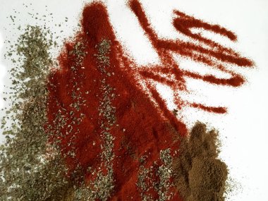 Doğu'nun sıcak boğucu nefes sıcak bir hatırlatma olarak beyaz bir arka plan üzerinde doymuş ateşli kırmızı, turuncu ve yeşil renklerin kurutulmuş baharatlı baharat ve otlar parçacıkların bir saçılma