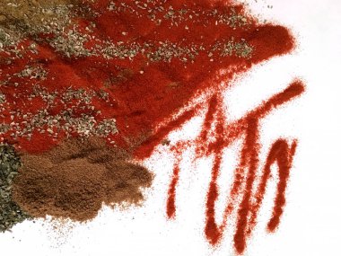 Doğu'nun sıcak boğucu nefes sıcak bir hatırlatma olarak beyaz bir arka plan üzerinde doymuş ateşli kırmızı, turuncu ve yeşil renklerin kurutulmuş baharatlı baharat ve otlar parçacıkların bir saçılma