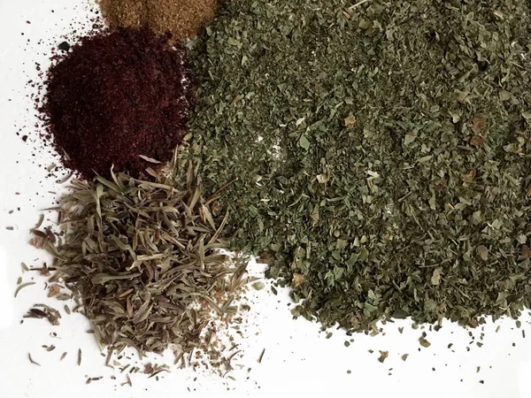 Doğu'nun sıcak boğucu nefes sıcak bir hatırlatma olarak beyaz bir arka plan üzerinde doymuş ateşli kırmızı, turuncu ve yeşil renklerin kurutulmuş baharatlı baharat ve otlar parçacıkların bir saçılma