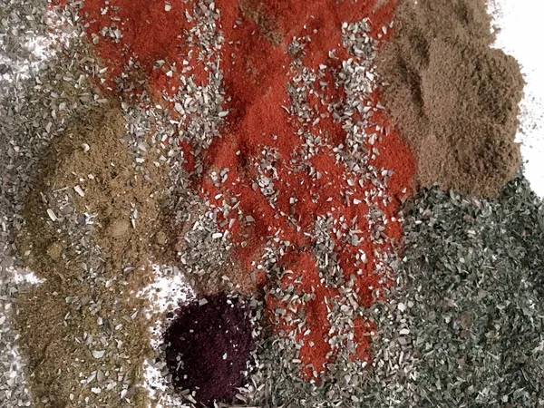 Doğu'nun sıcak boğucu nefes sıcak bir hatırlatma olarak beyaz bir arka plan üzerinde doymuş ateşli kırmızı, turuncu ve yeşil renklerin kurutulmuş baharatlı baharat ve otlar parçacıkların bir saçılma