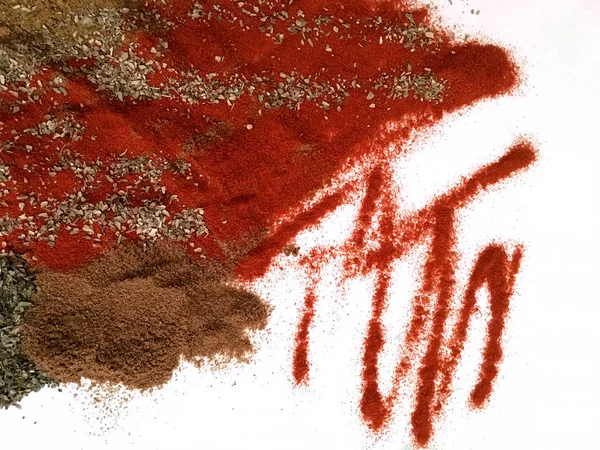 Doğu'nun sıcak boğucu nefes sıcak bir hatırlatma olarak beyaz bir arka plan üzerinde doymuş ateşli kırmızı, turuncu ve yeşil renklerin kurutulmuş baharatlı baharat ve otlar parçacıkların bir saçılma