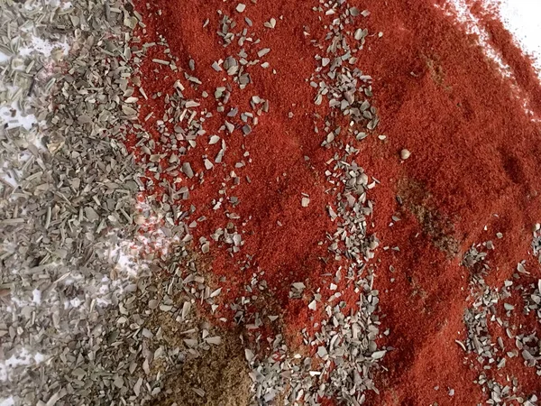 Doğu'nun sıcak boğucu nefes sıcak bir hatırlatma olarak beyaz bir arka plan üzerinde doymuş ateşli kırmızı, turuncu ve yeşil renklerin kurutulmuş baharatlı baharat ve otlar parçacıkların bir saçılma