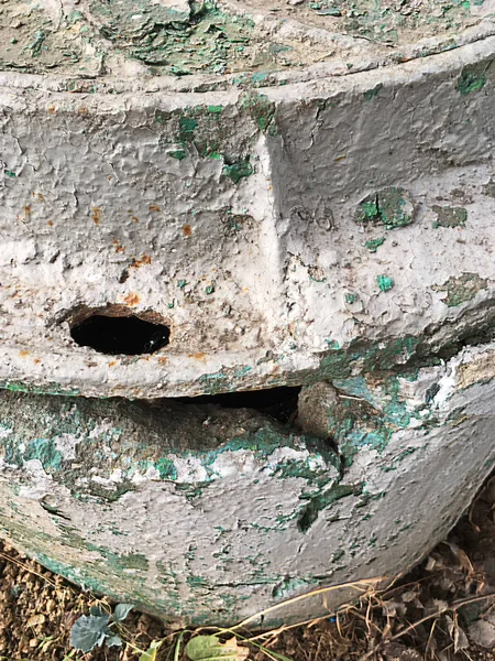 Kentsel yapıların bir unsuru olarak kahverengi, yeşil, gri boya katmanları ile kaplı harap bir rögar üzerinde eski kanalizasyon rögar,.