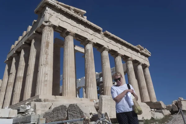 パルテノン神殿は アテナイのアクロポリスに古代建築の記念碑の背景に成熟した年齢の女性 — ストック写真