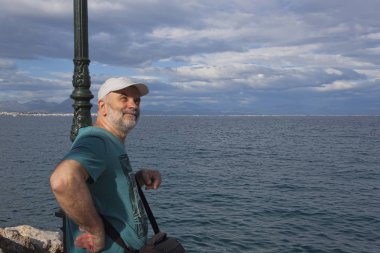 Olgun Yaş, deniz kıyısında ve mesafe içine bakarak bir adam portresi. Loutraki, Yunanistan