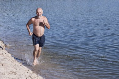 Olgun Yaş sakallı bir adam gölün kıyısında çalışır