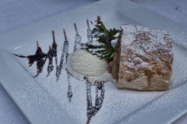 Dondurma ve çikolata ile Apple strudel. İnce pasta Konfeksiyon etrafında bir meyve dolgu yerleştirilmiştir ve pişmiş