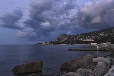 Karadeniz kıyısında sabah erken. Simeiz, Kırım, Ukrayna üzerinde dramatik gökyüzü