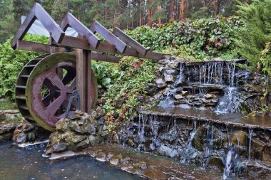 Ormandaki küçük bir yapay şelale yanında küçük bir watermill