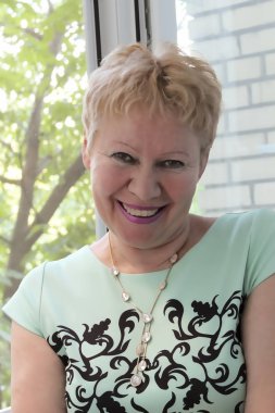 Gülümseyen bir kadının portresi. Siyah patter ile Hafif Salata elbise