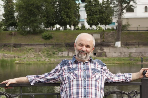 Ein Mann reifen Alters, Glatze mit Bart, in einem karierten Hemd auf der — Stockfoto