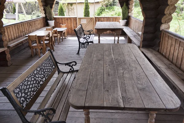 Σε ένα ξύλινο κτίριο πολλά ξύλινα τραπέζια και παγκάκια — Φωτογραφία Αρχείου