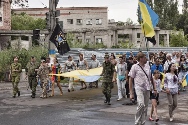 親ロシアの武装勢力からの解放の最初の記念日を記念して通りを通って都市住民の厳粛な行進 — ストック写真