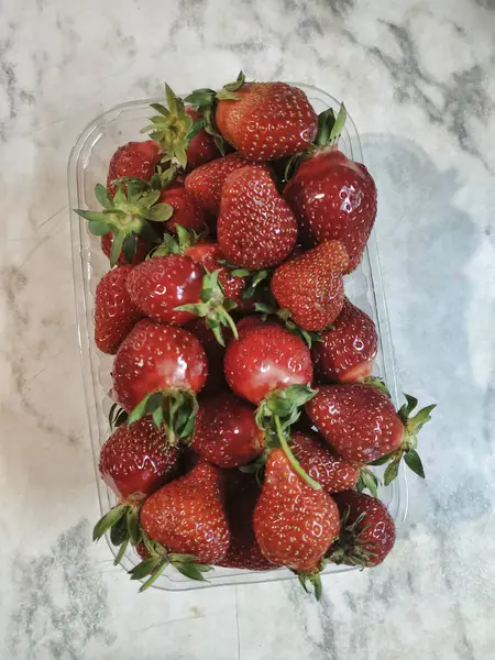 A tray with strawberries on a marbled table — Stock Photo, Image