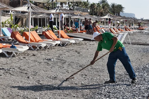 Trabajador de playa desconocido hace la limpieza — Foto de Stock