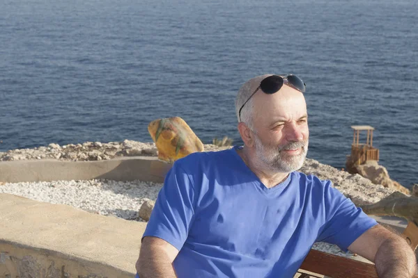 A mature man, bald, with a beard sits half-turn — Stock Photo, Image