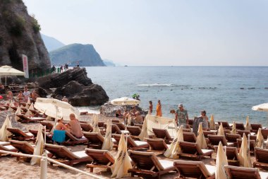 BUDVA, MONTENEGRO - 26 Haziran 2017: Budva Riviera 'nın en popüler plajlarından biri olan Budva' daki Mogren 'in kum ve çakıl taşı plajı