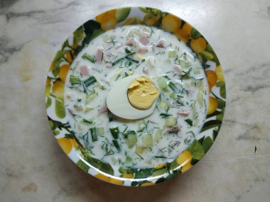 Masanın üzerinde okroshka ile bir tabak var, ortasında kaynamış bir yumurta var, ikiye bölünmüş. Yukarıdan ateş ediliyor