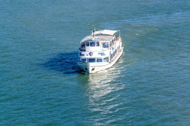 LINDAU, BAVARIA, GERMANY - 31 AĞUSTOS 2025: Güneşli bir günde Almanya 'nın Lindau limanı yakınlarında Constance Gölü' nün (Bodensee) mavi sularında seyahat eden turistlerle birlikte yolcu feribotu 'Uhldingen'