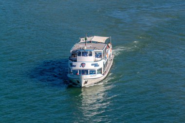 LINDAU, BAVARIA, GERMANY - 31 AĞUSTOS 2025: Güneşli bir günde Almanya 'nın Lindau limanı yakınlarında Constance Gölü' nün (Bodensee) mavi sularında seyahat eden turistlerle birlikte yolcu feribotu 'Uhldingen'