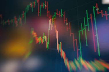 Borsa grafiği öndeki ekranda. Finans ve yatırım konsepti. Seçici odak