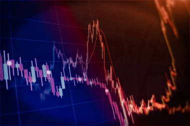 Borsa grafiği öndeki ekranda. Finans ve yatırım konsepti. Seçici odak