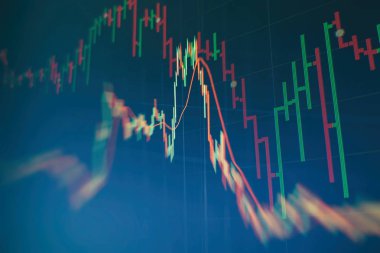 Borsa grafiği öndeki ekranda. Finans ve yatırım konsepti. Seçici odak