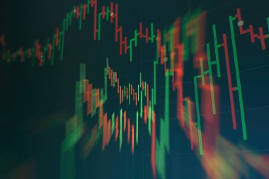 Borsa grafiği öndeki ekranda. Finans ve yatırım konsepti. Seçici odak