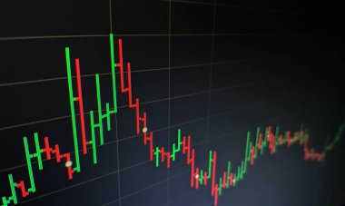 Borsa grafiği öndeki ekranda. Finans ve yatırım konsepti. Seçici odak